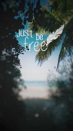 the words just be free are framed by palm trees