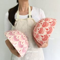 a woman in an apron holding two pillows