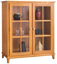 a wooden cabinet with glass doors on the front and bottom shelves filled with vases