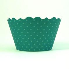 a green cupcake liner with white polka dots on the bottom, sitting in front of a white background