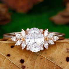 a diamond ring sitting on top of a leaf