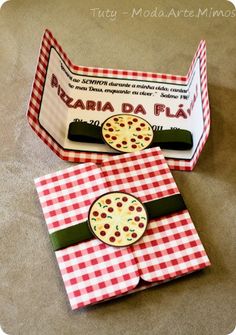 two pizza boxes are sitting on the floor with red and white checkered tablecloth