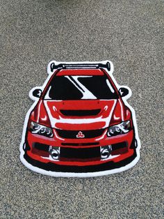 a red car sticker sitting on the ground