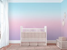 a baby's room with a crib, dresser and wall mural in pastel tones