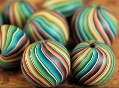 multicolored striped balls sitting on top of a wooden table