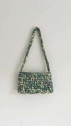 a green and white purse hanging on a wall