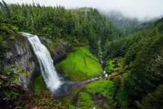 an aerial view of a waterfall surrounded by trees