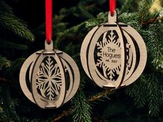 two ornaments hanging from a christmas tree with red ribbons on it's ends and the words the hags written in white