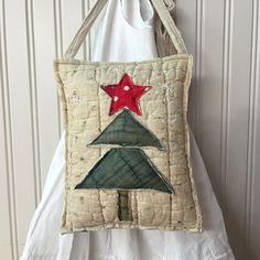 a handbag hanging on a wall with a red star and green christmas tree in the center