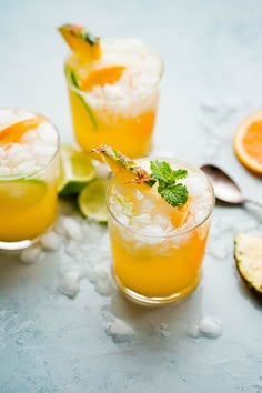 two glasses filled with orange juice and garnished with mint