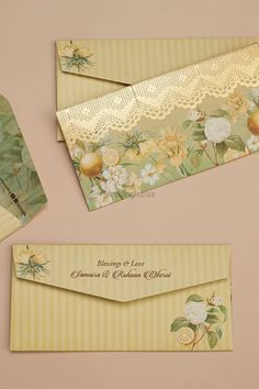 three envelopes with lace and flowers on them