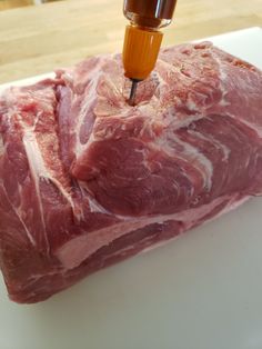 a piece of raw meat being cut into pieces with a small machine in the background