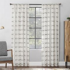 a living room with white curtains and a gray chair in front of a large window