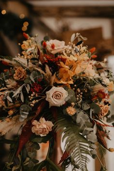 an arrangement of flowers and greenery in a vase