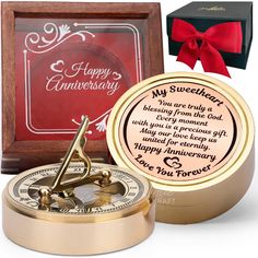 a gold compass is next to a red box and a happy anniversary card that says, my sweetest you are truly from the god