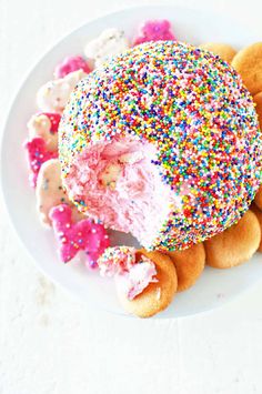 a white plate topped with donuts covered in sprinkles and frosting