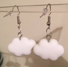 two white clouds hanging from hooks on a wall