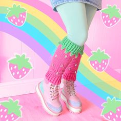 A woman is shown wearing a denim miniskirt, pastel green leggings, crochet bubblegum pink and pastel green leg warmers designed to look like a strawberry and pastel platform boots. The background has an illustrated wiggly pastel rainbow and pastel strawberries Strawberry Leg Warmers, Kidcore Outfit, Kidcore Fashion, Kawaii Kidcore, Kawaii Leg Warmers, Harajuku Girl, Strawberry Legs, Dopamine Dressing, Kawaii Crochet