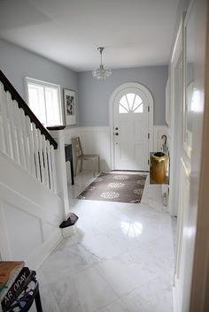 an entry way with a white door and stairs