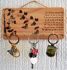 three key chains hanging from a wooden plaque with butterflies on it and a poem about love