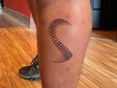 a man with a baseball tattoo on his leg