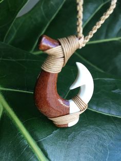 "KOA WOOD & BUFFALO BONE Tribal Design Fish Hook Pendant with Adjustable Cotton Cord Necklace Pendant: Approx. 33mm x 50mm Cord Necklace: Approx. 28\" long (Adjustable) This is a beautifully hand-crafted pendant made of natural koa wood in a traditional tribal fish hook design. Brown braided cotton necklace has an adjustable sliding knot to adjust the necklace into any desirable length. Wear it close to your neck as a choker or longer as a pendant/necklace. Keep in mind the shade of pendant Cotton Cord Necklace, Cotton Necklace, Koa Wood, Hook Design, Sliding Knot, Cord Necklace, Cotton Cord, Fish Hook, Necklace Pendant