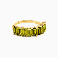 a yellow gold ring with green stones