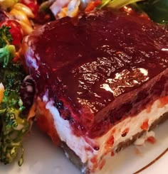 a piece of cake sitting on top of a white plate next to a pile of broccoli