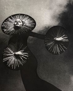 a woman with two parasols on her head is standing in front of a cloudy sky