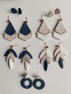 six pairs of earrings with different shapes and colors are shown in the image on a white surface