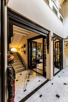 the entrance to a house with marble floors and black trimmings on the doors