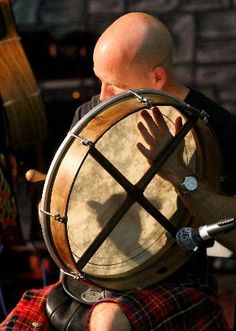 a man in kilt playing the drums on stage