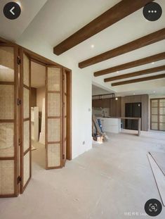 an empty room with wooden beams and white walls