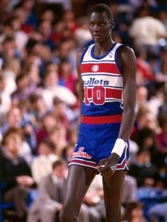 a man standing on top of a basketball court in front of a crowd at a game