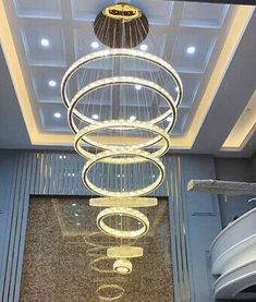 a chandelier hanging from the ceiling in a room with marble floors and walls