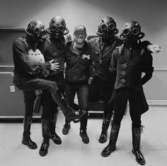 five people in gas masks posing for a photo