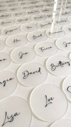 many white plates with names on them are arranged in rows and lined up against each other