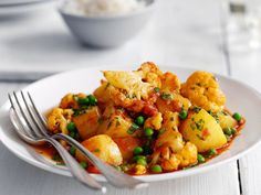 a white plate topped with cauliflower and peas