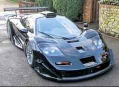 a black sports car parked in front of a house