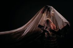 a woman wearing a veil and sitting in a chair with her hands on her hips