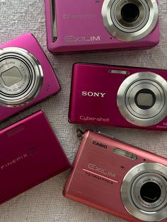 four pink digital cameras sitting next to each other