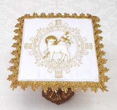 an ornate gold and white box with a horse on it's side, sitting on a table