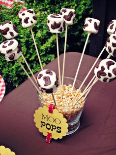 chocolate covered marshmallows in a glass bowl on a table with a sign that says moo pops