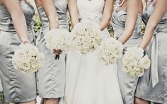 a group of bridesmaids standing in front of each other holding bouquets with white flowers