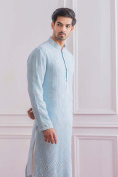 Editor's Note Featuring An Elegant Powder Blue Kurta With Intricate Mirror Work On Front And Sleeves. Perfect For An Outdoor Occasion For The Modern Groom Or Groomsmen. This Comes With Cotton Lining And Ivory Classic Churidaar Color: Blue Fabric: Pure Georgette Care: Dry Clean Only About the Designer Ankit V Kapoor is a clothing brand that amalgamates traditional Indian handicrafts and bespoke tailoring. Inspired by the heritage of India and unified with revolutionary thoughts. Specialize in Men Powder Blue Kurta For Men, Intricate Mirror, Ganesh Puja, Modern Groom, Gents Kurta, Indian Handicrafts, Blue Kurta, Kurta Set For Men, Men's Ethnic Wear