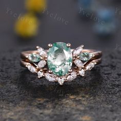 an oval cut green and white diamond ring with three pear shaped diamonds on each side