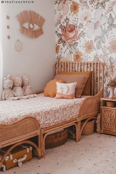 a child's bedroom with floral wallpaper and wooden furniture