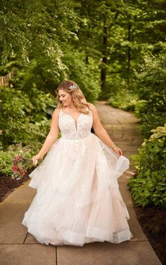 a woman in a wedding dress walking down a path