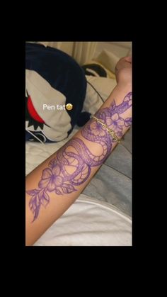 the arm is covered with purple tattoos on it's sides and arms are decorated with flowers