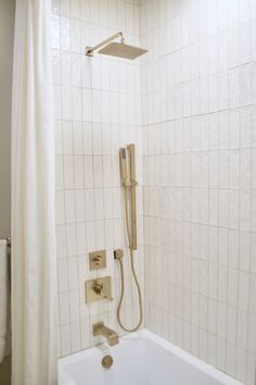 the shower head is attached to the wall above the bathtub